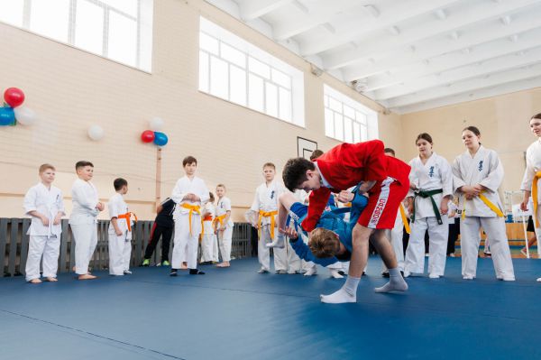 «Чтобы каждый мог заниматься борьбой». В школе Кировграда появился ролл-мат для самбо и дзюдо, детям их вручали чемпионы мира